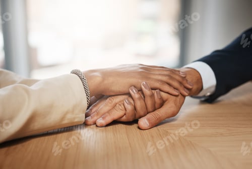 Preview: Closeup shot of two unrecognizable businesspeople holding hands in an office