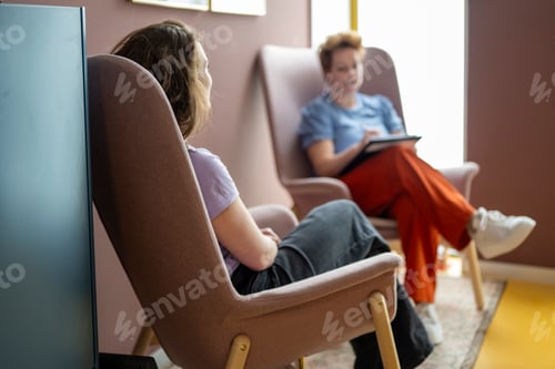 Preview: Two women engaged in an indoor conversation