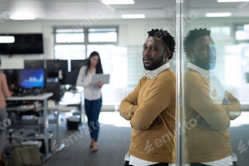 Preview: Portrait of businessman with arms crossed at modern office