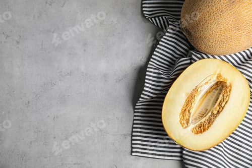 Preview: Tasty ripe melons on grey table, flat lay. Space for text