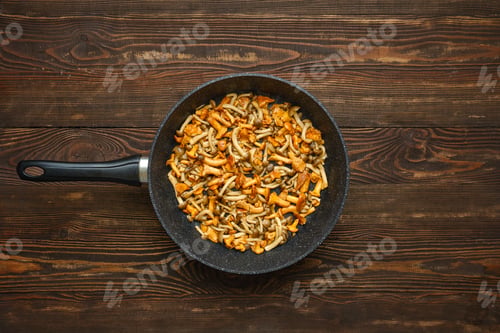 Preview: Delicious mushroom stir-fry prepared in a skillet on a wooden table