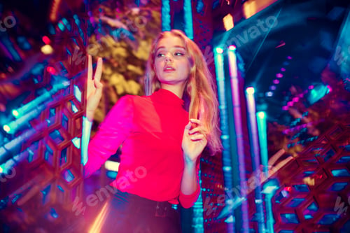 Preview: Cinematic portrait of handsome young woman in neon lighted room, stylish musician