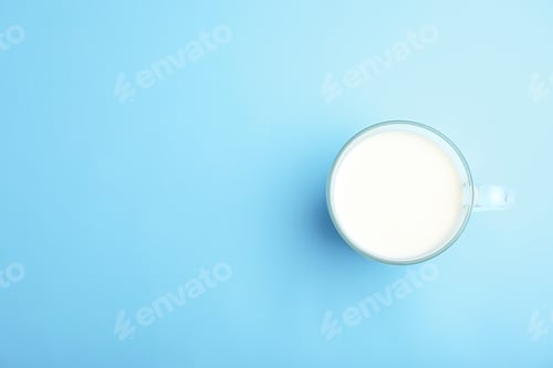 Preview: Cup of fresh milk on color background, top view. Space for text