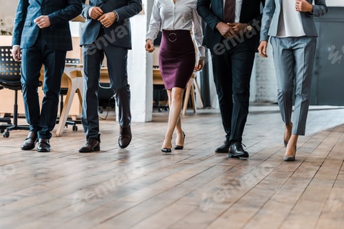 Preview: cropped view of multicultural businessmen and businesswomen walking in office