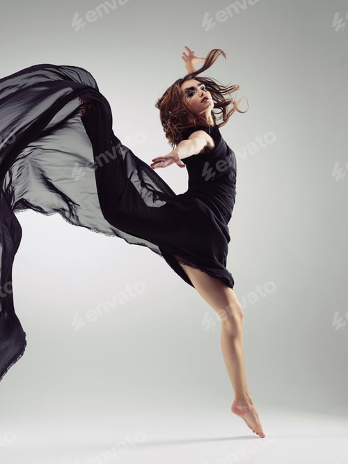Preview: Studio shot of a beautiful young woman in a flowing dress against a gray background