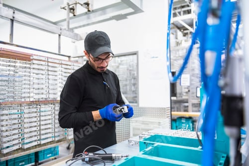 Preview: Man working in factory shop floor looking at product