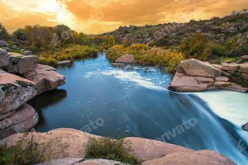 Preview: Stream runs among white wet stones covered with grass in golden autumn