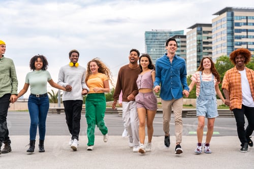 Preview: Happy playful multiethnic group of young friends bonding outdoors