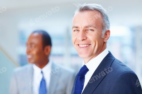 Preview: Senior executive smiling with colleague in background