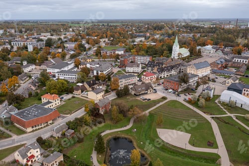 Preview: Aerial view of a charming town with colorful trees and green spaces during autumn