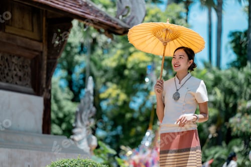 Preview: Beautiful Thai Woman Holding Traditional Umbrella in Lanna Dress near Temple