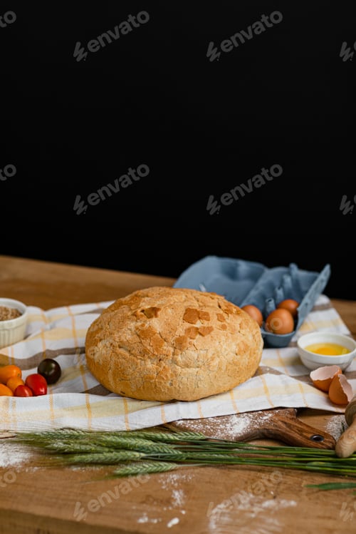 Preview: Gold rustic crusty bread on a wooden board with tomatoes and other ingredients