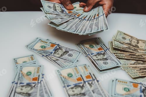 Preview: African American or black man at home counting money wealth and saving concept