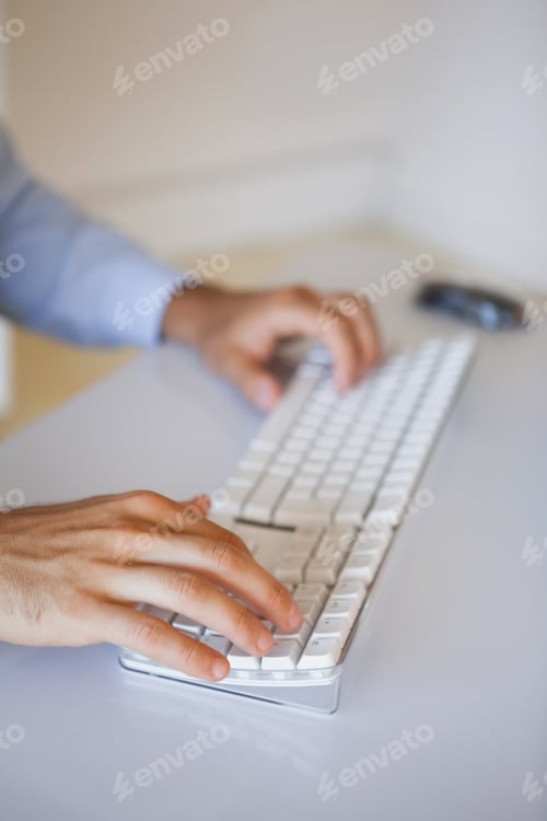 Preview: Businessman typing on keyboard at desk in his office