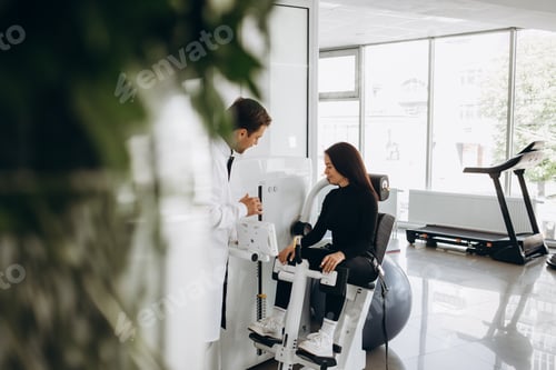 Preview: Young woman making spine examination in diagnostics machine with physiotherapist.