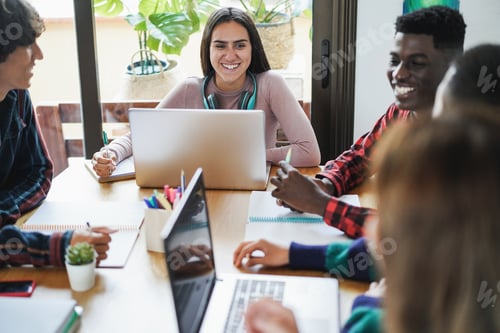 Preview: Multiracial students using laptop computers while studying together at school