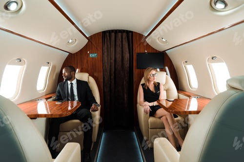 Preview: selective focus of handsome african american businessman and attractive businesswoman sitting in