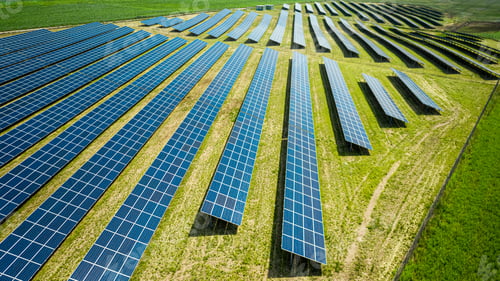 Preview: Closeup of blue solar panels on green field, aerial view