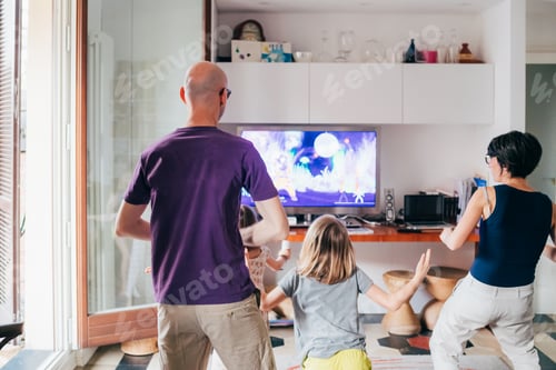 Preview: Family dancing together indoor playing videogame