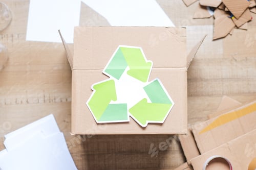 Preview: Top View Of Recycling Symbol On Cardboard Box With Various Craft Materials