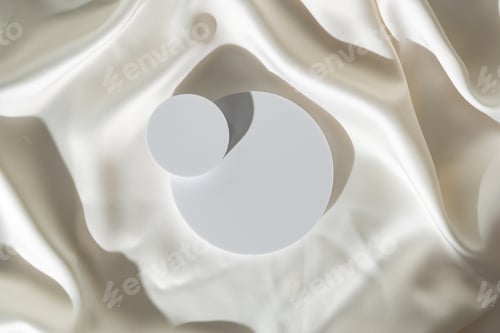 Preview: Modern Minimalist White Sculpture Displayed on Soft Draped Fabric in Natural Light