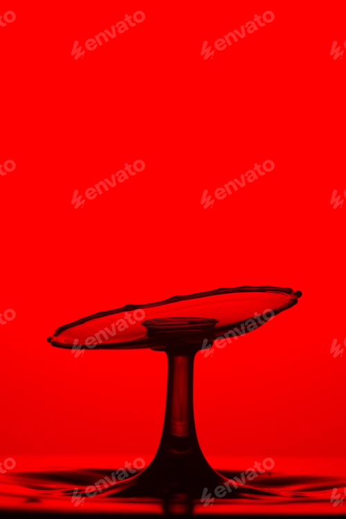 Preview: Closeup shot of splash of transparent liquid on red background
