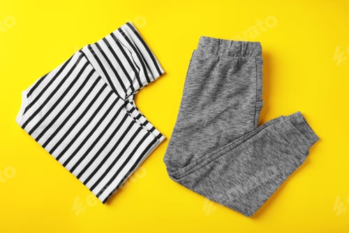Preview: Flat lay composition with cute child clothes on color background