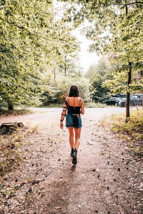 Preview: Young female is walking down a rural dirt road, surrounded by lush greenery