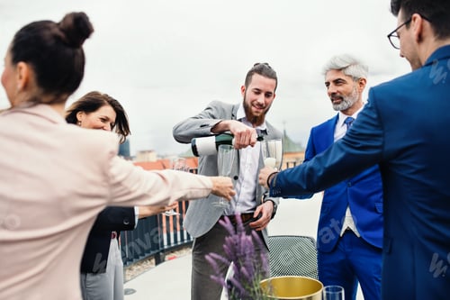 Preview: A group of joyful businesspeople having a party outdoors on roof terrace in city