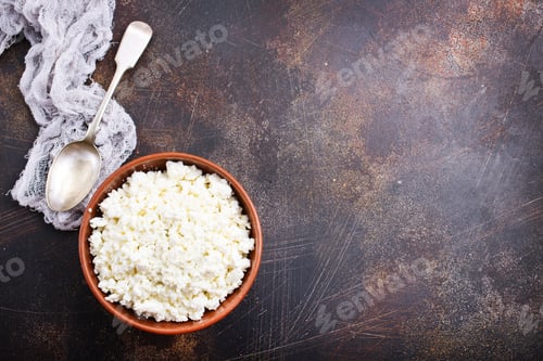 Bowl of cottage cheese with spoon and cloth