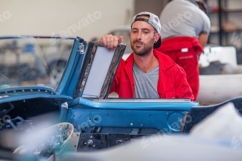 Preview: Mechanics restoring vintage cars in workshop