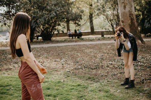 Preview: Young Women Taking Pictures in a Green Park