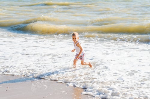 Preview: Child Runs Through Foamy Waves at the Beach