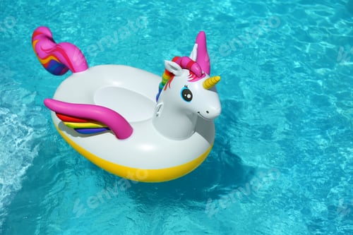 Preview: Funny inflatable unicorn ring floating in swimming pool on sunny day. Space for text