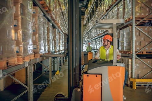 Preview: Lots To Do. Warehouse Worker In Helmet Standing In The Warehouse And Looking At The Shelves With