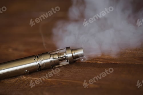 Preview: Electronic cigarette on a wooden table. Smoke