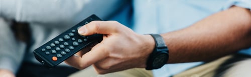 Preview: cropped view of man holding remote control in hand