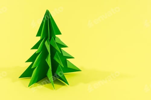 Preview: Green origami tree isolated on a yellow background
