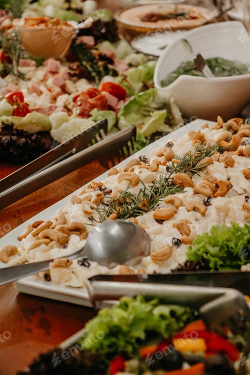 Preview: several salads and side dishes on a long table for the food