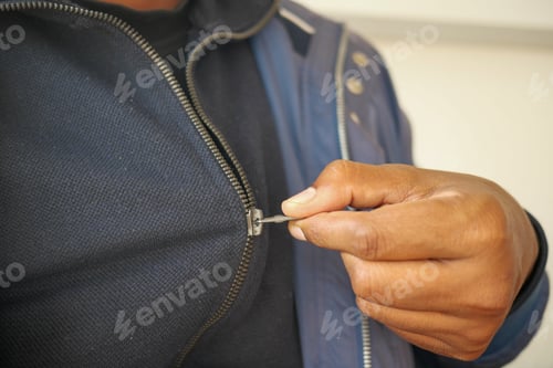 Preview: Man zipper on a jacket in cold autumn day.