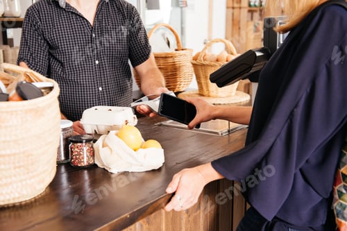 Preview: Close-Up of Customer Making a Smartphone Payment at a Grocery Store Counter