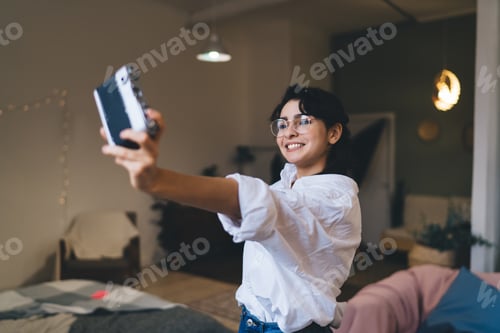 Preview: Positive woman shooting selfie in room