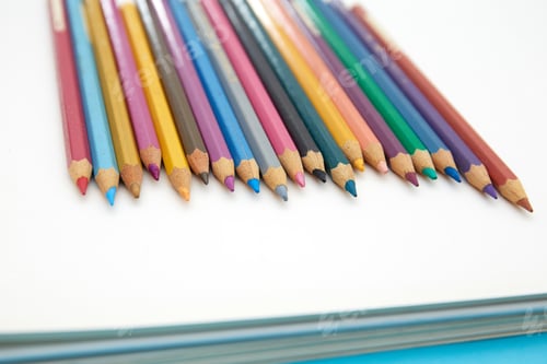 Preview: Colorful pencils on a blank notebook
