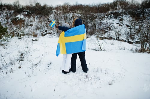 Preview: Scandinavian couple with Sweden flag in winter swedish landscape.