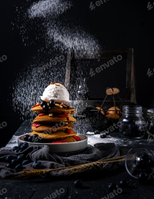Preview: Pancakes with vanilla ice cream berries and sugar powder splashes in dark background. For breakfast.