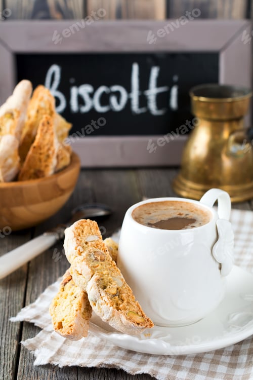Preview: Homemade biscotti with nuts and a cup of coffee on the old wooden table background. Selective focus