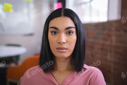 Vista previa: Portrait of mixed race businesswoman sitting at work in meeting room