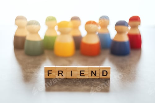 Preview: FRIEND word on wooden blocks with a group of people in the background