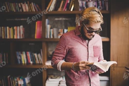 Preview: Hipster bearded man reading book in cafe.