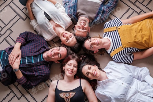 Preview: Group of young friends lying down overhead view smiling and spending an afternoon together.
